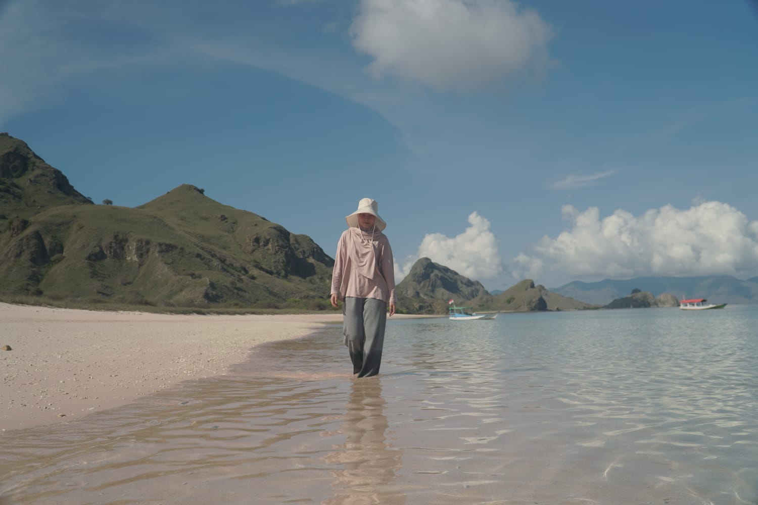 Ein Tourist oder Reisender spaziert am rosafarbenen Strand des Komodo-Nationalparks.