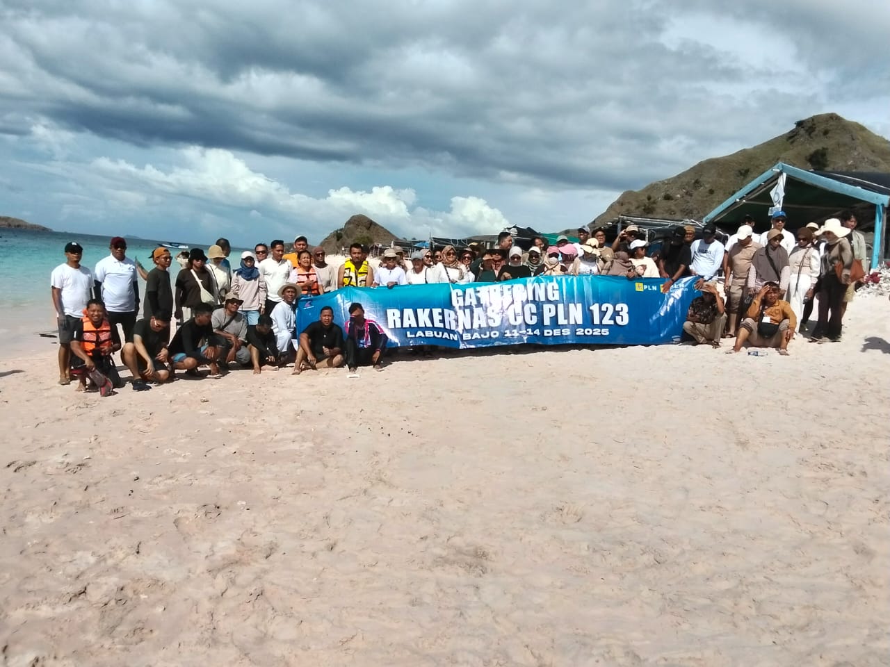 Eine Gruppe Reisender, die am Pink Beach im Komodo-Nationalpark nördlich der Insel Padar Fotos machen.